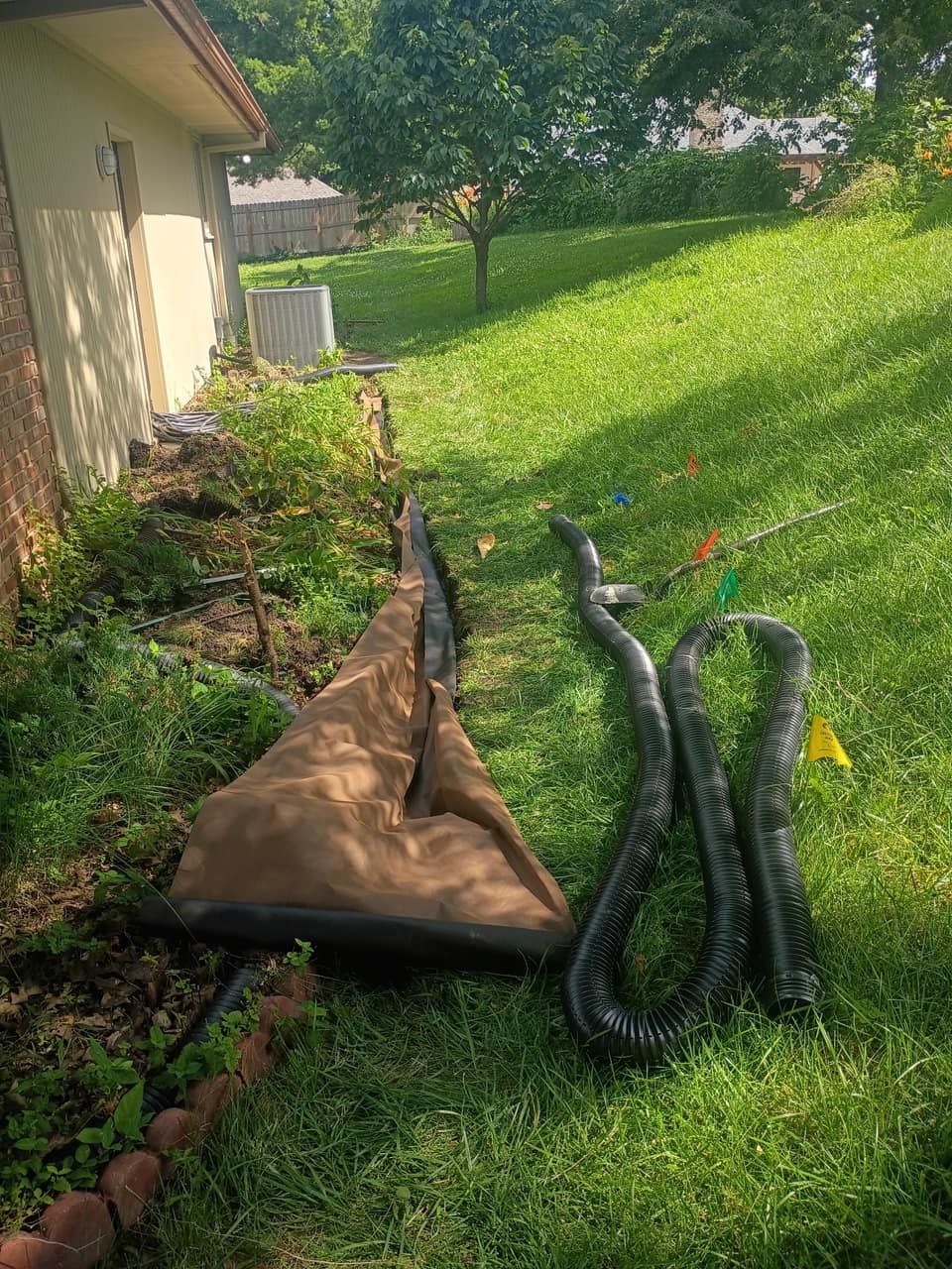 Corrugated drainage pipe laid out beside the open trench