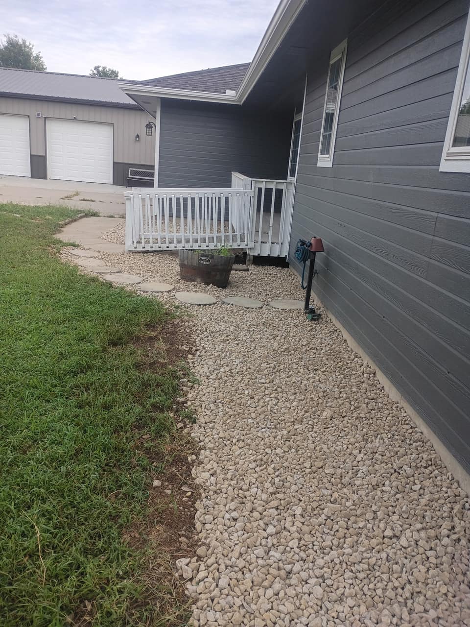 Clean white gravel bed running along the house beside the walkway