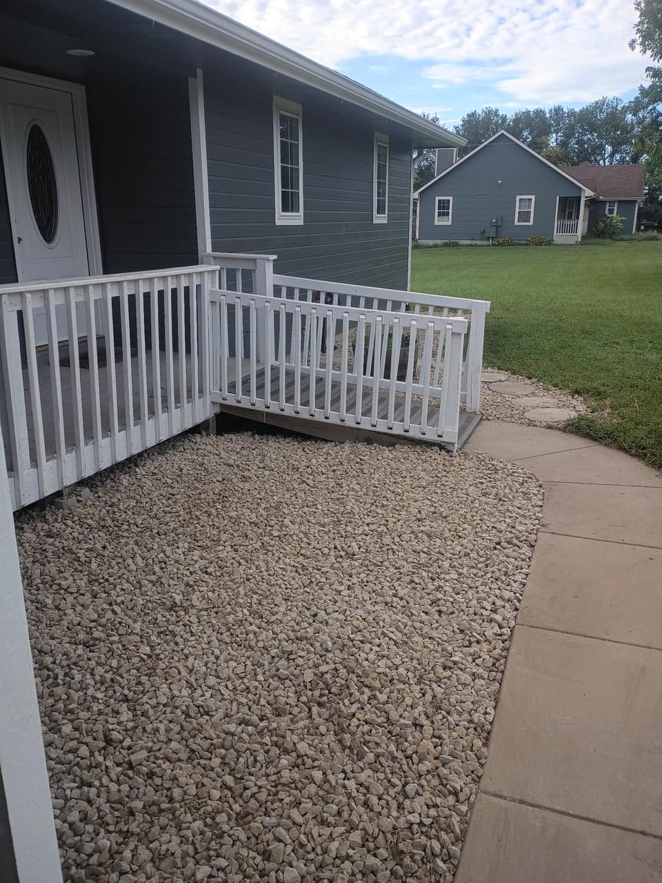 Finished gravel bed meeting the front walkway and porch rail